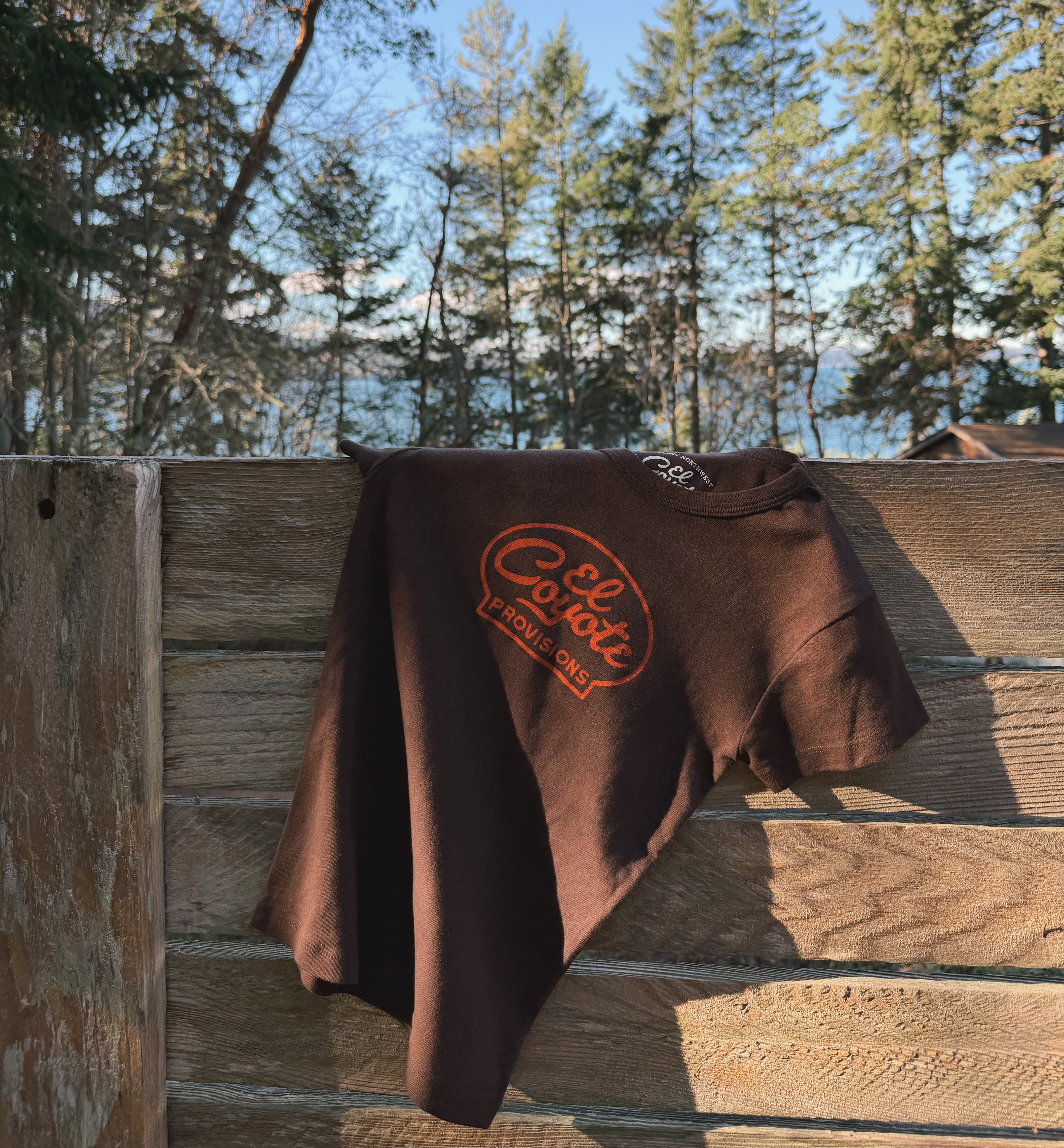 Brown T-Shirt with lettering logo in red on center front of shirt.